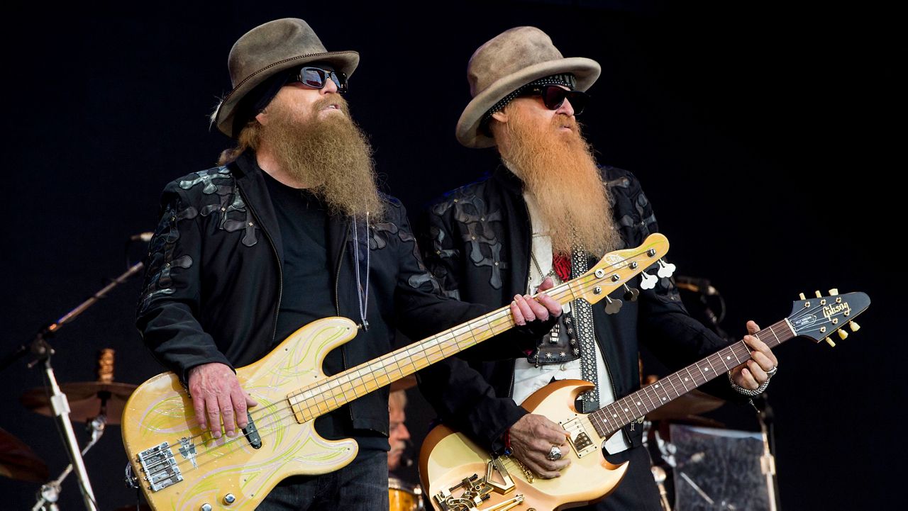 FILE - Dusty Hill, left, and Billy Gibbons from U.S rock band ZZ Top perform at the Glastonbury music festival in Somerset, England, June 24, 2016. ZZ Top has announced that Hill, one of the Texas blues trio's bearded figures and bassist, has died at his Houston home. He was 72. In a Facebook post, bandmates Billy Gibbons and Frank Beard revealed Wednesday, July 29, 2021, that Hill had died in his sleep. (Photo by Jonathan Short/Invision/AP, File)