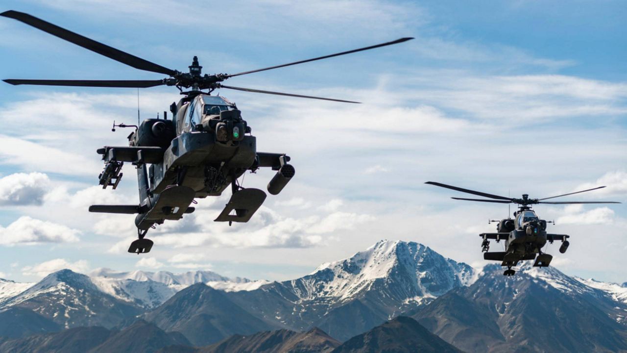 In this photo released by the U.S. Army, AH-64D Apache Longbow attack helicopters from the 1st Attack Battalion, 25th Aviation Regiment, fly over a mountain range near Fort Wainwright, Alaska on June 3, 2019.
