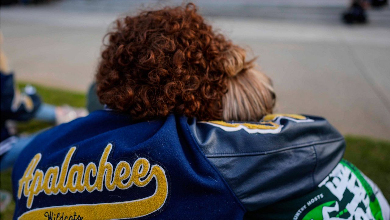 Mourners listen to a speaker during a candlelight vigil for the slain students and teachers at Apalachee High School, Wednesday, Sept. 4, 2024, in Winder, Ga. (AP Photo/Mike Stewart)
