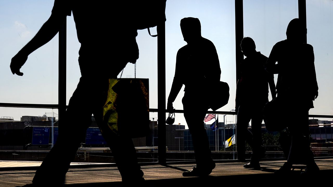 Arriving passengers move toward the baggage claim area at Philadelphia International Airport in Philadelphia on Friday, July 1, 2022.