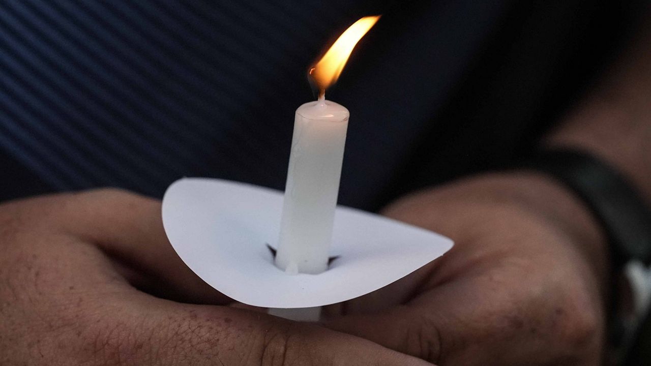 Mark Gorman holds a candle during a candlelight vigil for the slain students and teachers at Apalachee High School, Wednesday, Sept. 4, 2024, in Winder, Ga. (AP Photo/Mike Stewart)