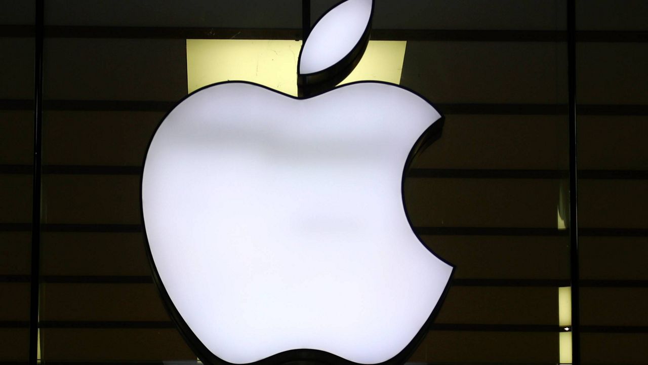 The Apple logo is illuminated at a store in the city center of Munich, Germany, Dec. 16, 2020. (AP Photo/Matthias Schrader, File)