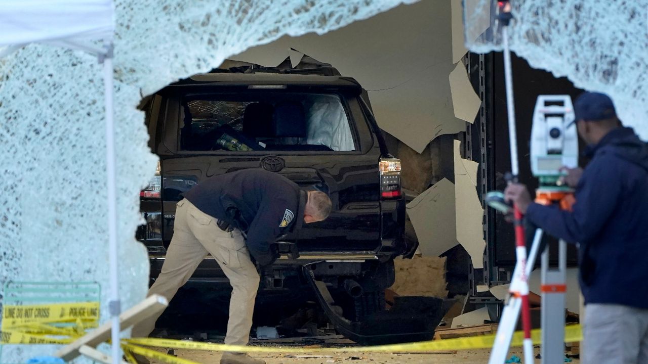 A law-enforcement official examines an SUV inside an Apple Store on Monday in Hingham, Mass. (AP Photo/Steven Senne)