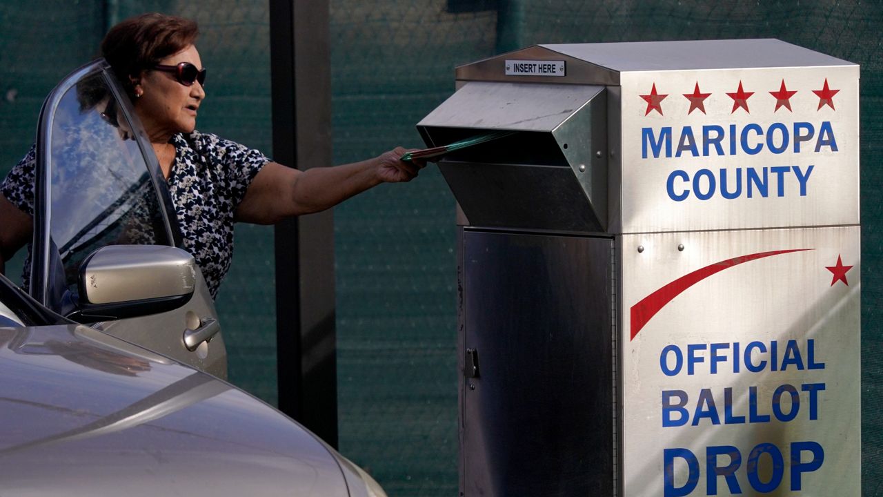 A voter casts her ballot Tuesday at a secure ballot drop box at the Maricopa County Tabulation and Election Center in Phoenix. (AP Photo/Matt York)