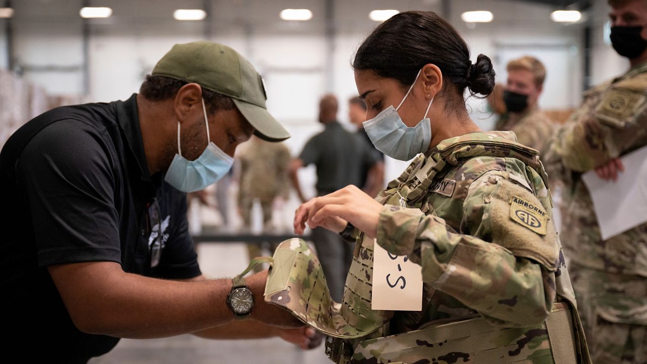 In this image provided by the U.S. Army, Sgt. Katiushka Rivera, a soldier assigned to the 82nd Airborne gets fitted for a modular scalable vest (MSV) during a fielding event in Fort Bragg, N.C., on Sept. 13, 2021. (Jason Amadi/U.S. Army via AP)