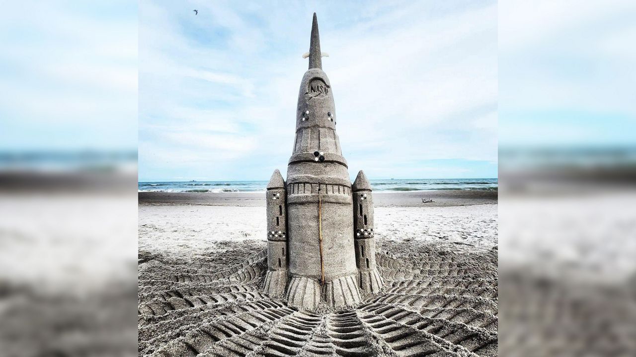 Sand sculptor Janel Hawkins says she created a representation of the Artemis I rocket to pay tribute to this week's historic launch. (Spectrum News/Greg Pallone)