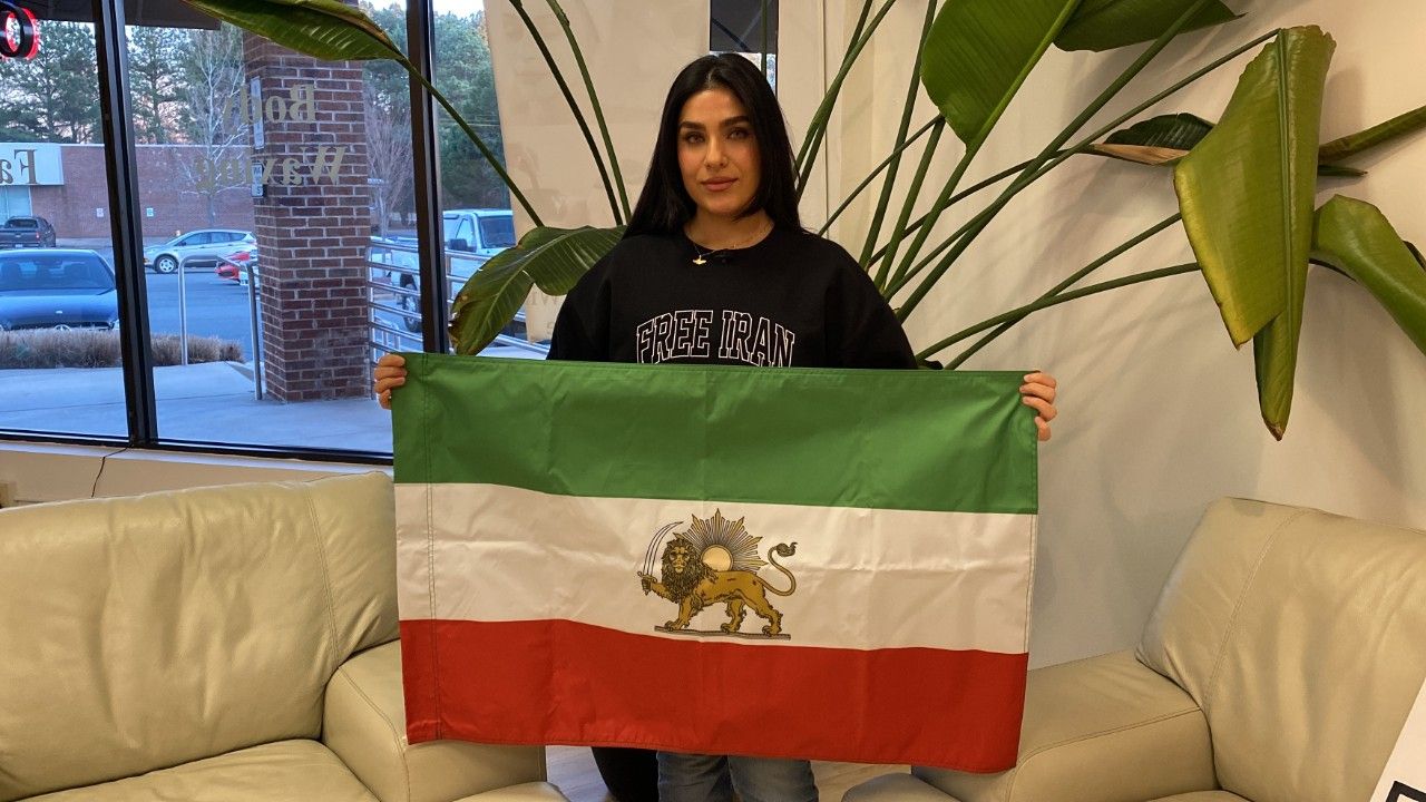 Asal, who joined a rally Friday at the state Capitol in Raleigh, holds an Iranian flag. (Spectrum News 1/Kyleigh Panetta)