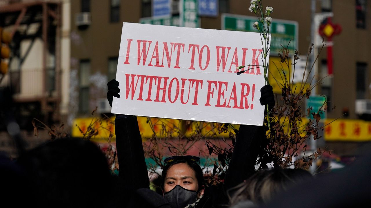 People hold signs during a rally in response to the killing of Christina Yuna Lee in the Chinatown section of New York, Monday, Feb. 14, 2022. Lee was stabbed to death inside her lower Manhattan apartment by a man who followed her from the street into her building, authorities said.