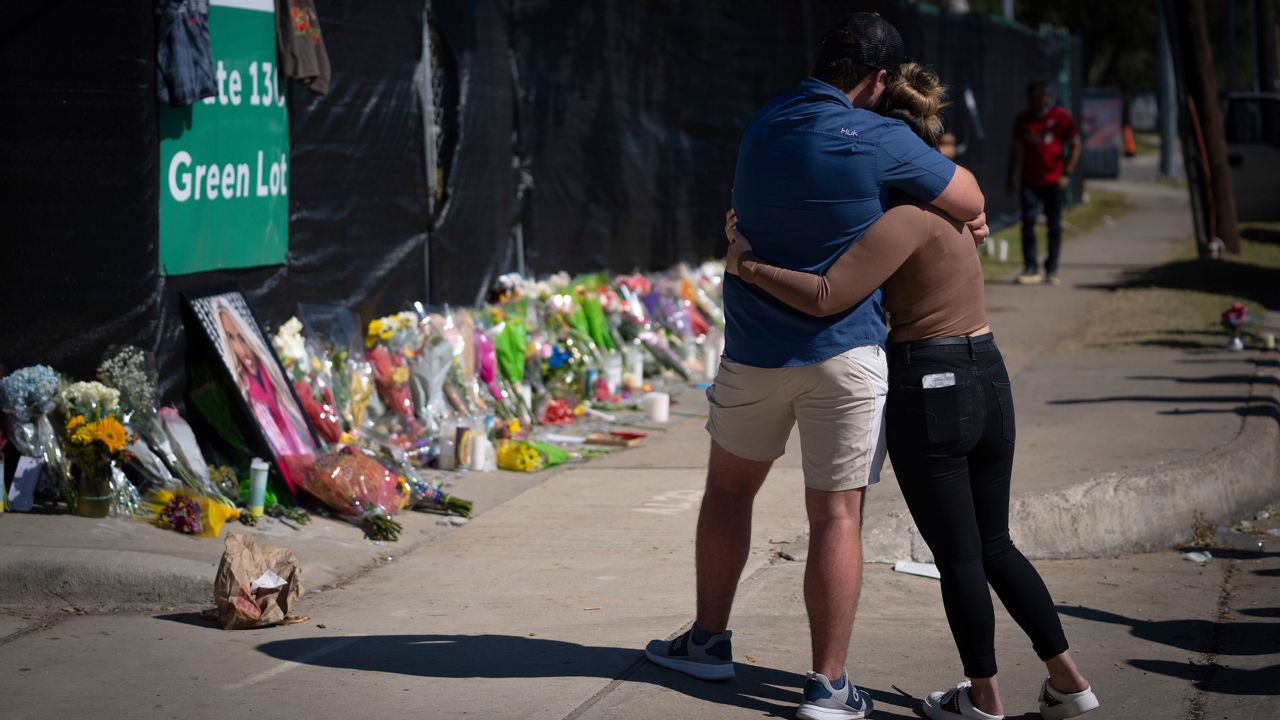 FILE - Two people who knew an unidentified victim of a fatal incident at the Houston Astroworld concert embrace at a memorial on Sunday, Nov. 7, 2021. A new task force will look into how to improve the safety at large Houston-area events in the hopes of avoiding another tragedy like last year's deadly Astroworld music festival, officials said Wednesday, Feb. 9, 2022. (AP Photo/Robert Bumsted, File)