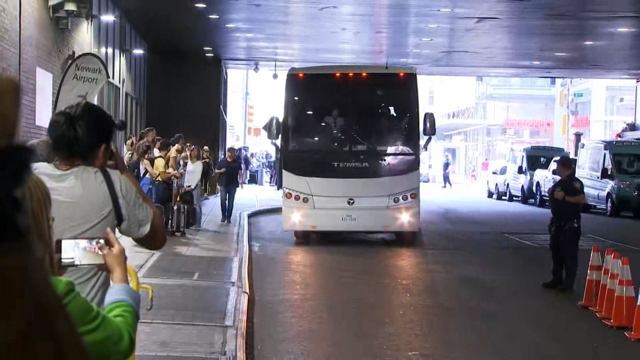 Front shot of a bus pulling up with recently arrived migants