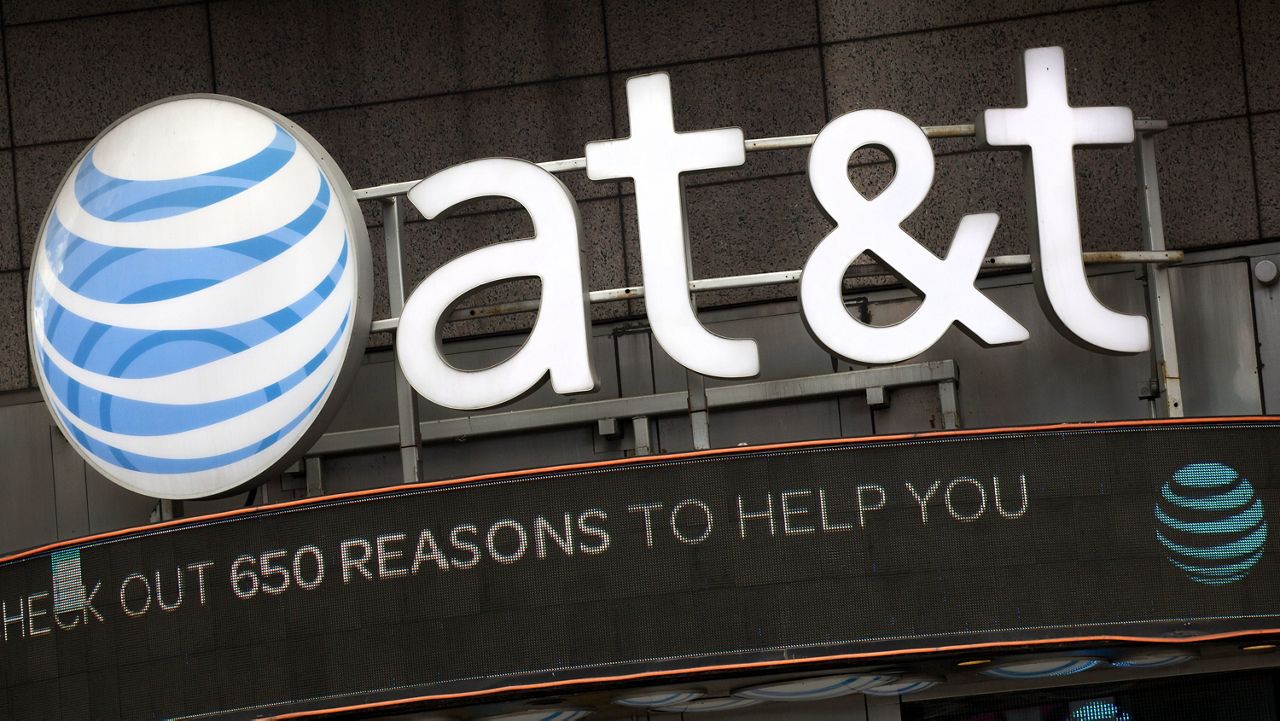 The AT&T logo is positioned above one of its retail stores in New York, Oct. 24, 2016. (AP Photo/Mark Lennihan, File)