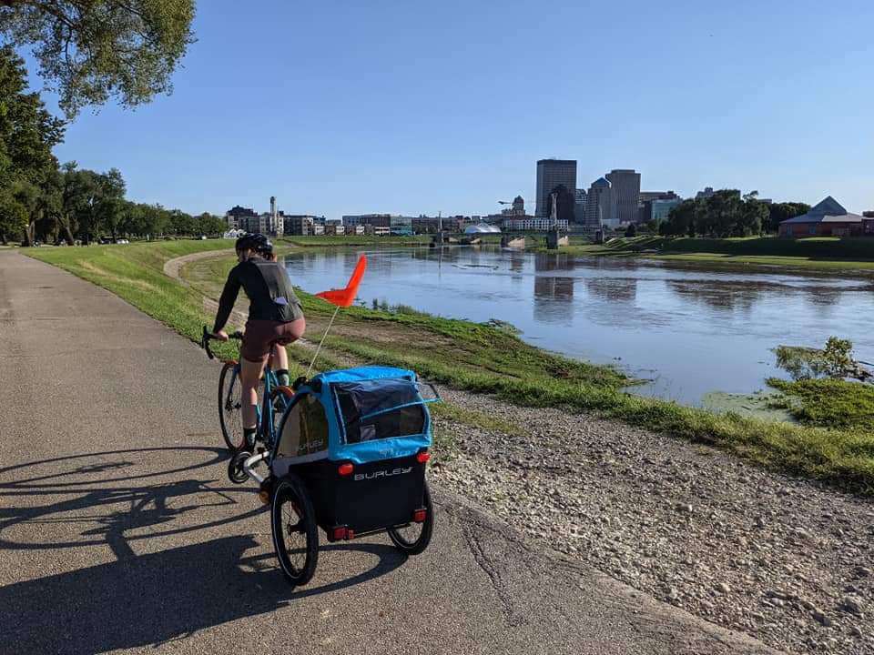 Dana Vingris rides her bike with her child in tow along the RiverScape bike trail in Dayton, Ohio. (Photo courtesy of Ryan Vingris)