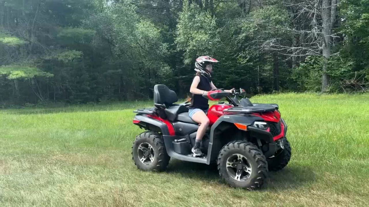 Woman riding an ATV in the woods