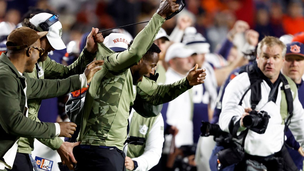 Auburn interim head coach Carnell Williams, center, reacts to his first win after the team defeated Texas A&M in an NCAA college football game Saturday, Nov. 12, 2022, in Auburn, Ala. (AP Photo/Butch Dill)