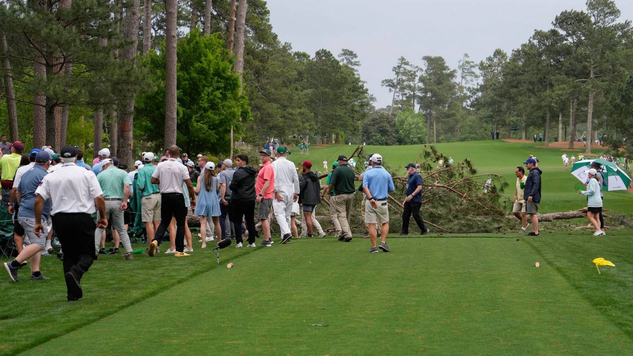 Patrons move away from trees that blew over on the 17th hole during the second round of the Masters golf tournament at Augusta National Golf Club on Friday, April 7, 2023, in Augusta, Ga. Ga. A day later there is no visible sign that trees fell on the course. (AP Photo/Mark Baker, File)