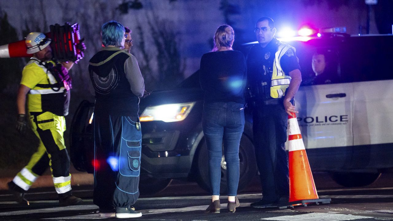 Neighborhood residents speak to Austin Police officers in Austin, Texas late Tuesday, Dec. 5, 2023. Texas authorities say a daylong series of attacks in Austin has left four people dead and at least three injured, and a man believed to be connected to them and the deaths of two people near San Antonio was taken into custody. (Sara Diggins /Austin American-Statesman via AP)