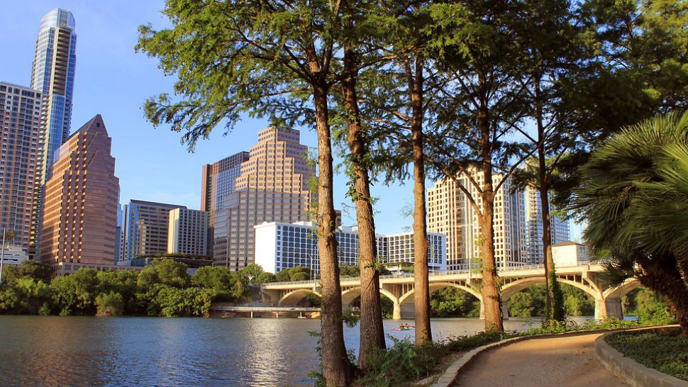 The Austin skyline sits in the distance behind trees and water. (Spectrum News file photograph)