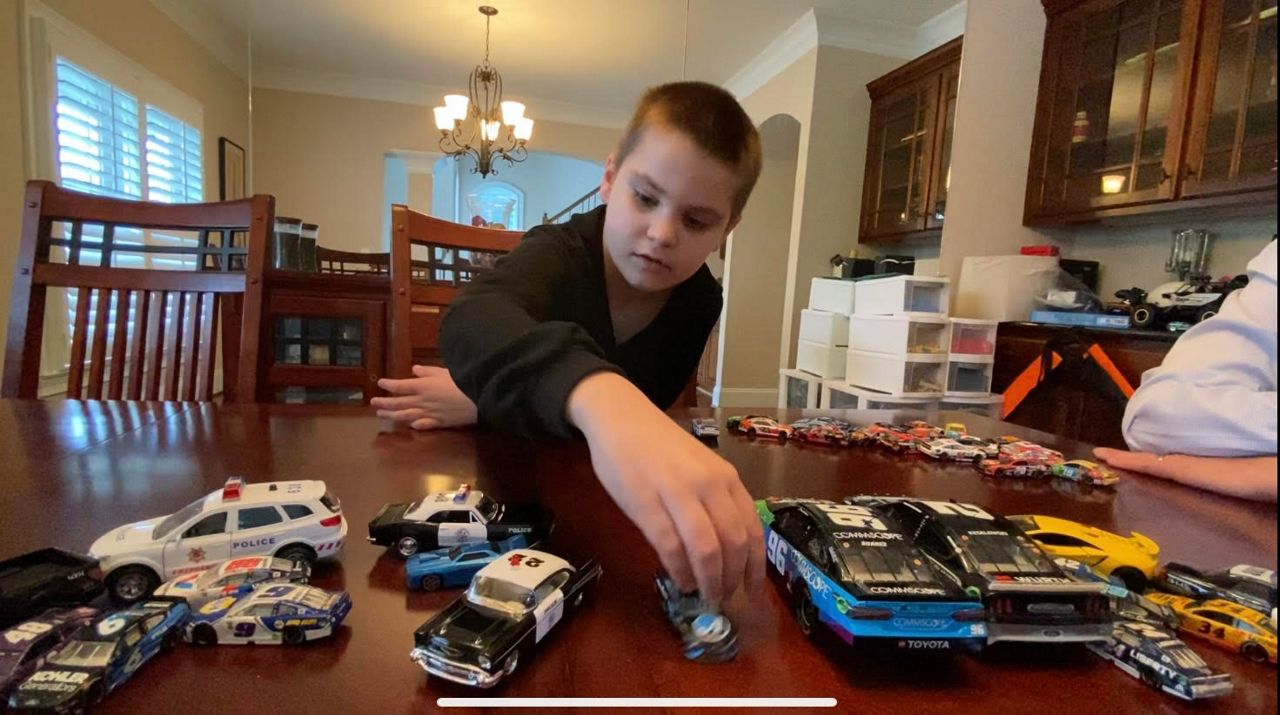 Carter playing with NASCAR hot wheel toys