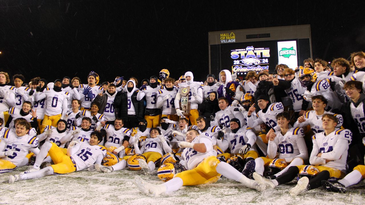 The Avon High School football team stands together with the Division II state championship trophy after the OHSAA football state championship game at Tom Benson Hall of Fame Stadium on Thursday. (Jacob Benge)