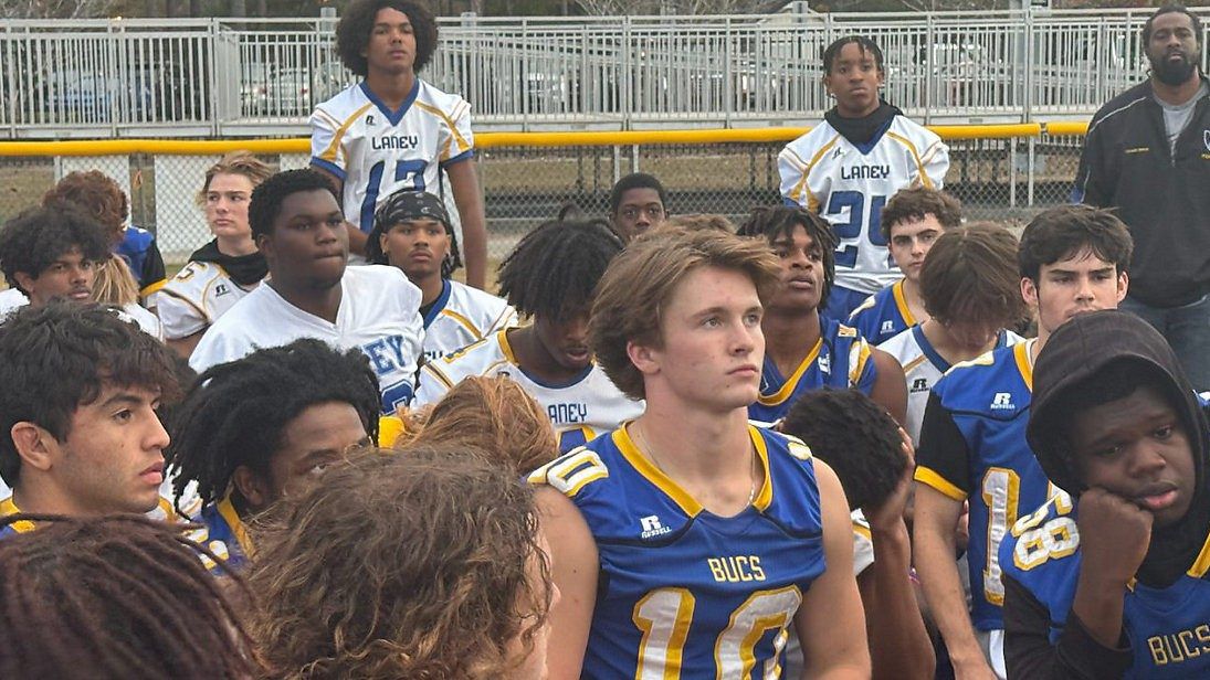 Ayden Rogers, center, and teammates on the Laney High School football team listen to a pep talk from their head coach. (Spectrum News 1/Alex Wilkinson)