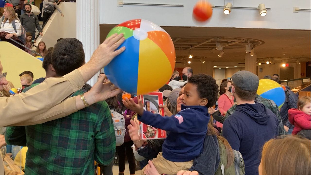 A good samaritan hands off a beach ball during Saturday's 'Noon Year's Eve' celebration at the EcoTarium.