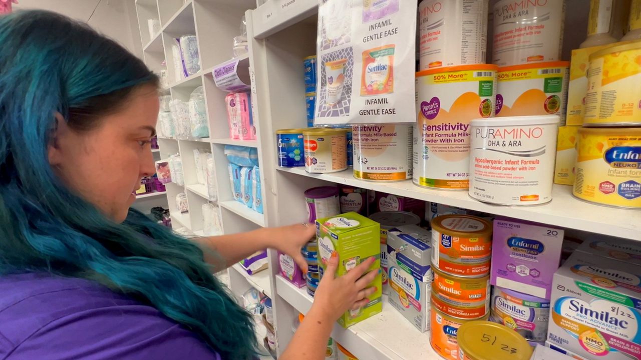 Martha Brookley, with Mothers Helping Mothers, goes through donated infant formula that will be distributed to families who need it. (Spectrum Bay News 9/Gabrielle Arzola)
