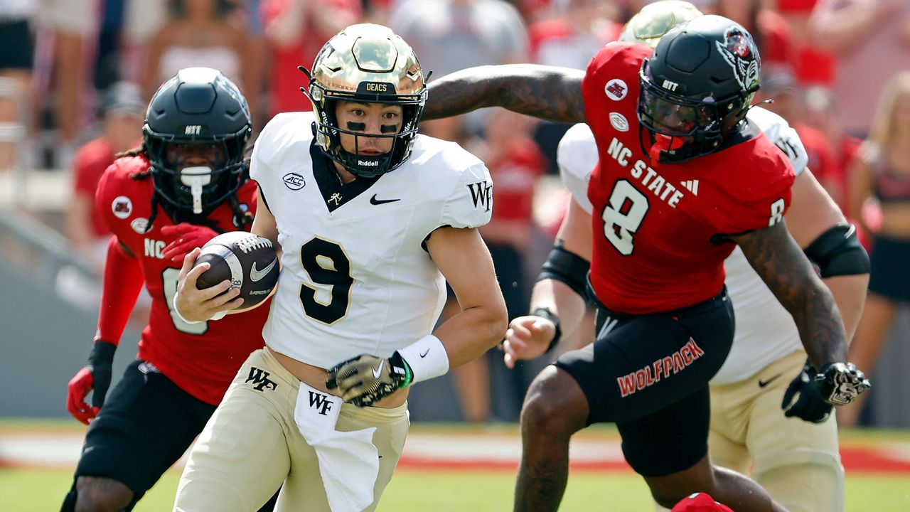 Wake Forest quarterback Hank Bachmeier (9) runs the ball as N.C. State's Devon Betty (8) and Sean Brown (0) chase him during the first half of an NCAA college football game in Raleigh, N.C., Saturday, Oct. 5, 2024. (AP Photo/Karl B DeBlaker)