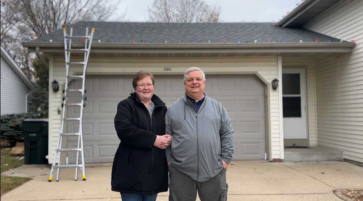 Anita and Christopher Bagwell smile in front of their new holiday light display
