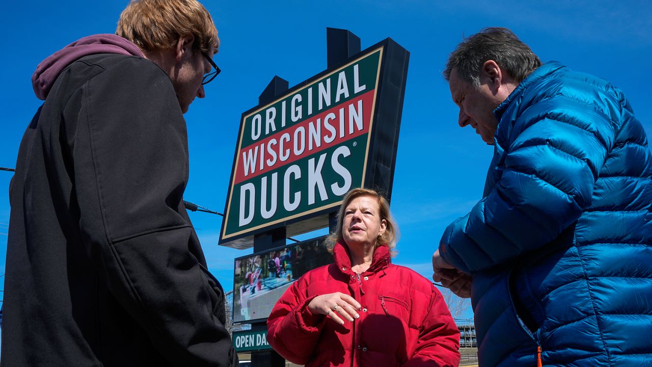Wisconsin Democratic U.S. Sen. Tammy Baldwin talks to Dan Gavinski, right, and Chase Slack 