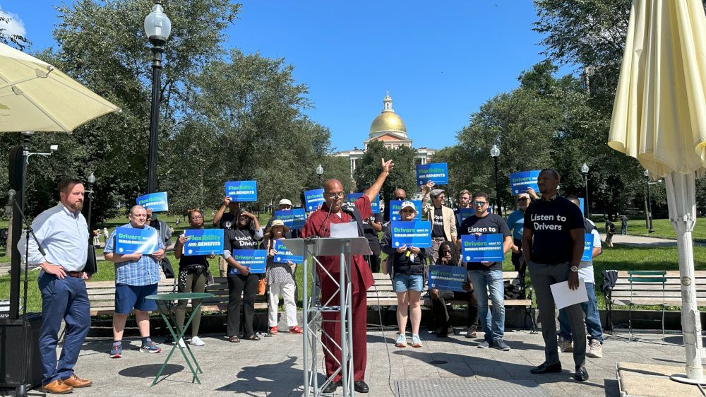 Supporters rallied Wednesday on Boston Common for an industry-backed ballot question related to app-based drivers, including speaker Charles Clemons Muhammad (center). (State House News Service/Sam Doran)