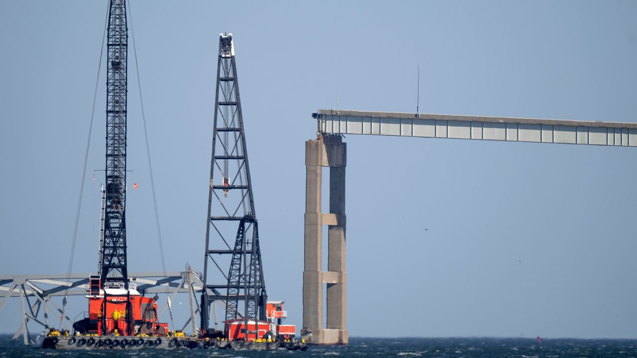 Barges with cranes float near a damaged section of the Francis Scott Key Bridge on Friday, March 29, 2024 in Baltimore.