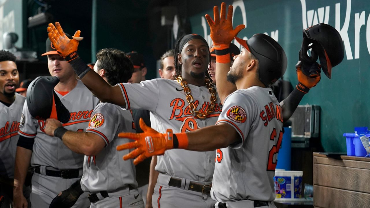 Baltimore Orioles shortstop Jorge Mateo, center, and Anthony Santander, right, celebrate in the dugout after Mateo hit a two-run home run in the ninth inning of a baseball game against the Texas Rangers, Tuesday, Aug. 2, 2022, in Arlington, Texas. The shot also scored Terrin Vavra. (AP Photo/Tony Gutierrez)