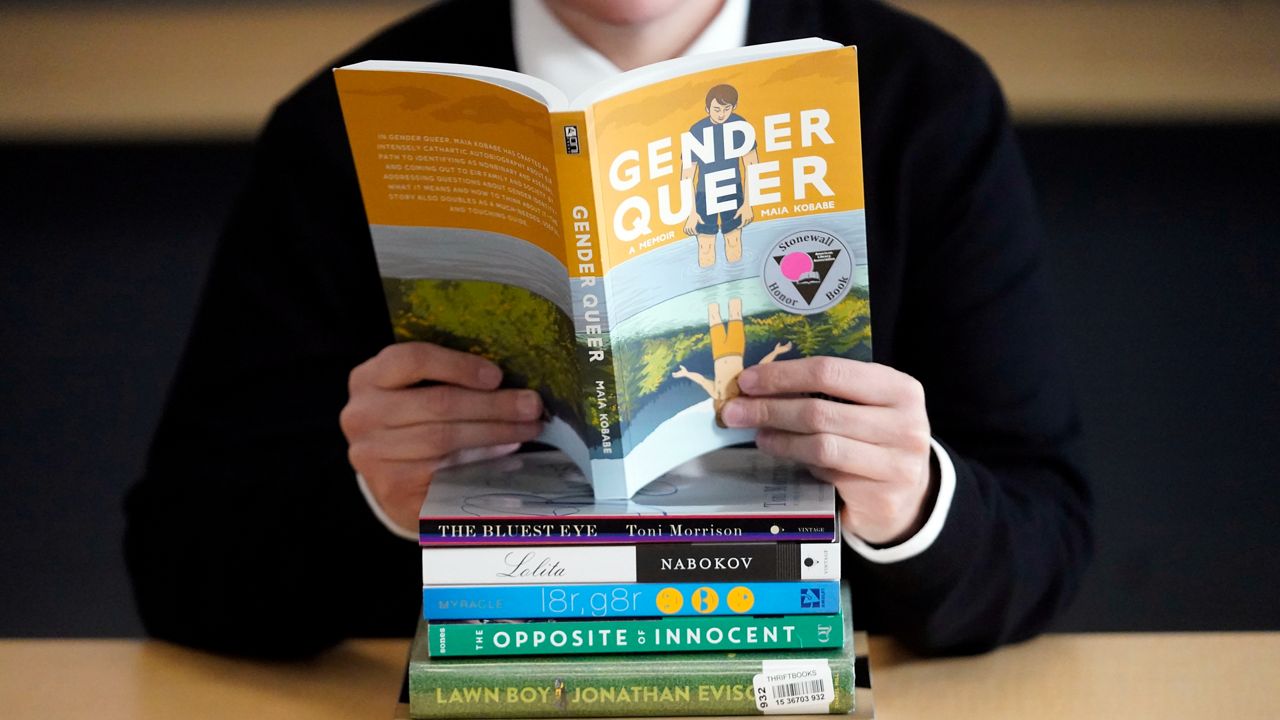 A pile of challenged books appear at the Utah Pride Center in Salt Lake City on Dec. 16, 2021. Attempted book bannings and restrictions at school and public libraries continue to surge, according to a new report from the American Library Association. (AP Photo/Rick Bowmer, File)