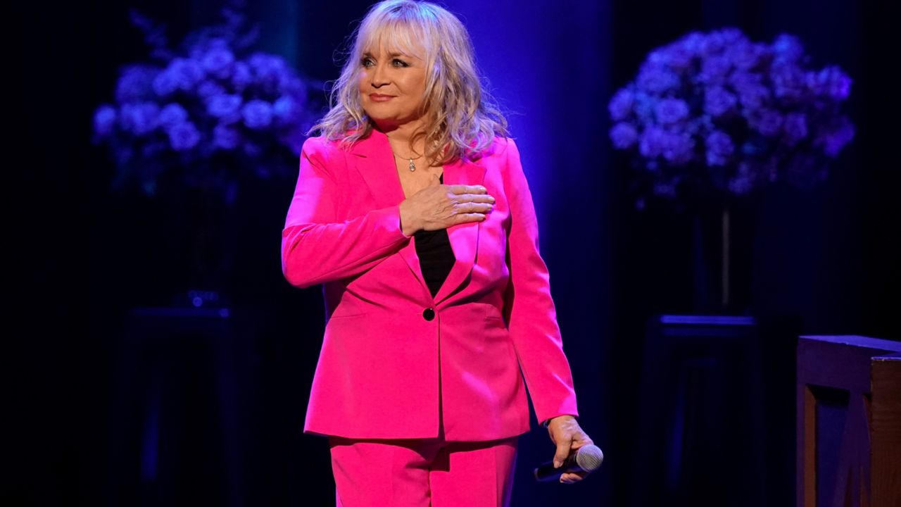 Barbara Mandrell acknowledges the applause as she walks onto the stage at the Grand Ole Opry House during a celebration of her 50th anniversary as a member of the Grand Ole Opry, Saturday, July 30, 2022, in Nashville, Tenn. (AP Photo/Mark Humphrey)