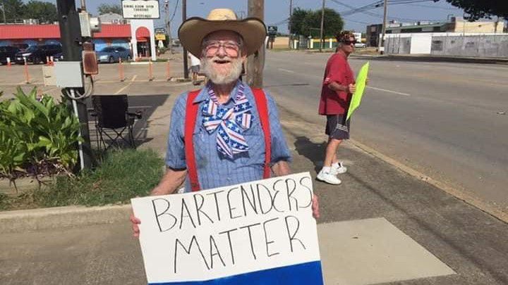 A protester on Division Street holds up a sign to oncoming traffic. (Photo courtesy of Pearl's Cherokee Lounge.)