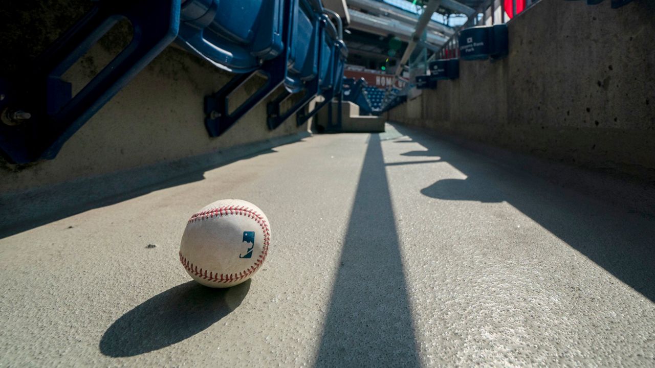 FILE - In this Sunday, July 26, 2020, file photo, a foul ball that was hit into the stands sits on the ground of an empty stadium during the eighth inning of a baseball game between the Miami Marlins and the Philadelphia Phillies in Philadelphia. The Marlins' coronavirus outbreak could endanger the Major League Baseball season, Dr. Anthony Fauci said, as the number of their players testing positive rose to 15. The Marlins received positive test results for four additional players Tuesday, July 23, 2020, a person familiar with the situation told The Associated Press. (AP Photo/Chris Szagola, File)