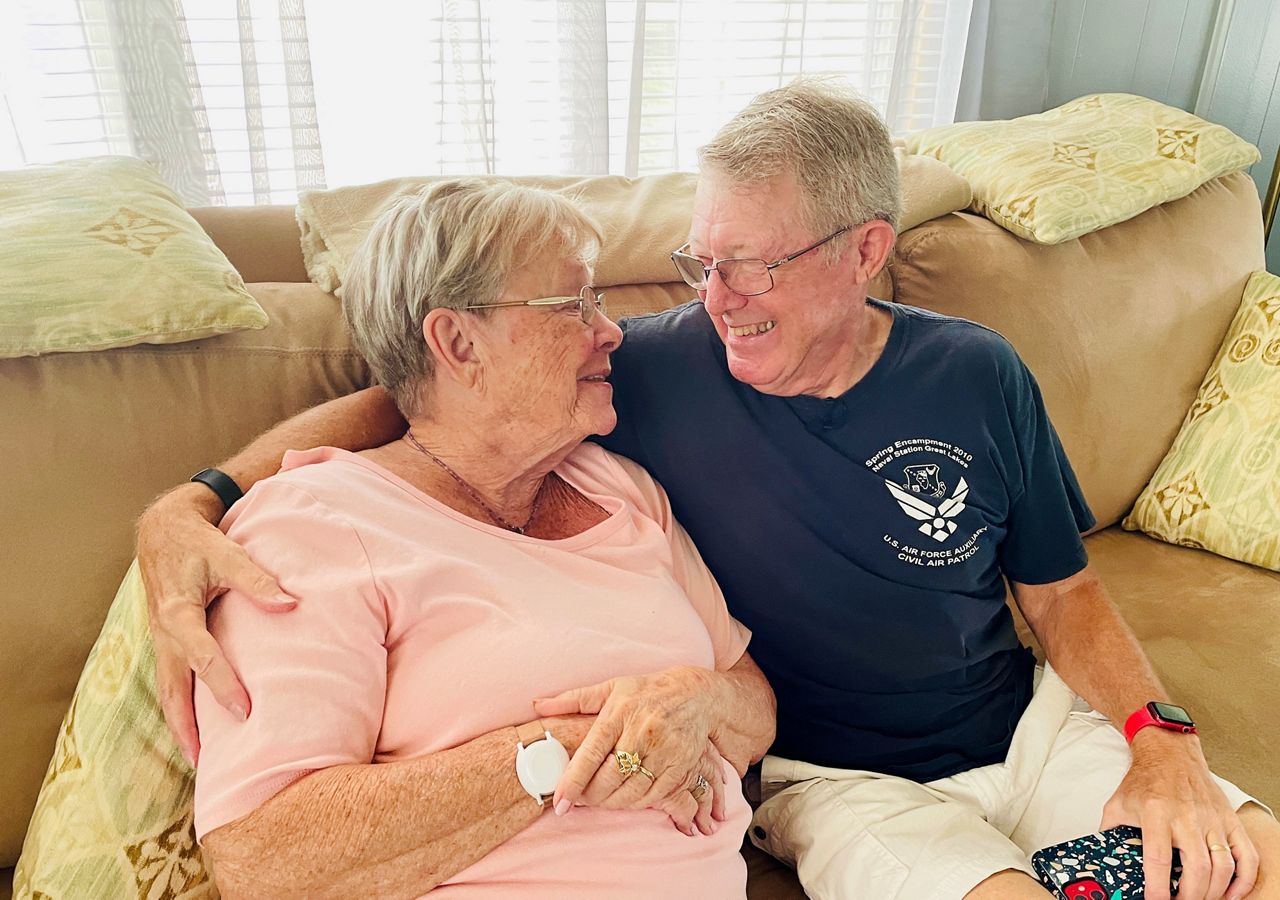 Gayle and Gary Sprigg embrace inside their Largo home. (Spectrum News)