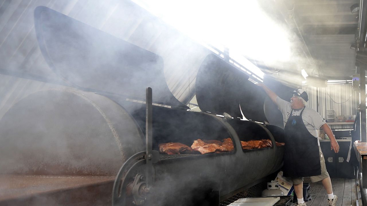 Rock Moye, from Austin, Texas, prepares brisket to serve to volunteers and flood victims in the aftermath of Hurricane Harvey on Sunday, Sept. 3, 2017, in Cypress, Texas. (AP Photo/David J. Phillip)