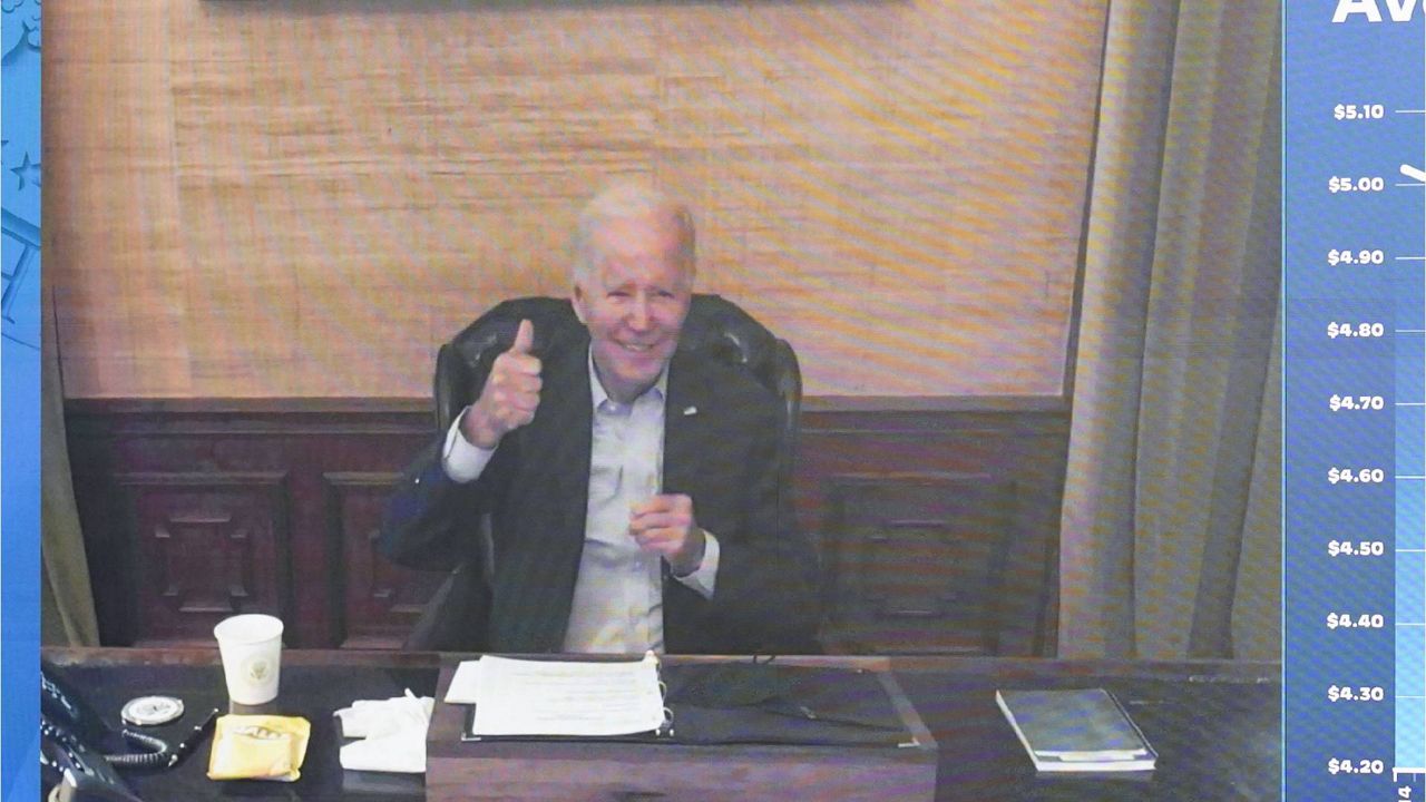 President Joe Biden gives a thumbs up after being asked by members of the media how he is feeling as he speaks virtually during a meeting with his economic team in the South Court Auditorium on the White House complex in Washington, Friday, July 22, 2022. (AP Photo/Andrew Harnik)