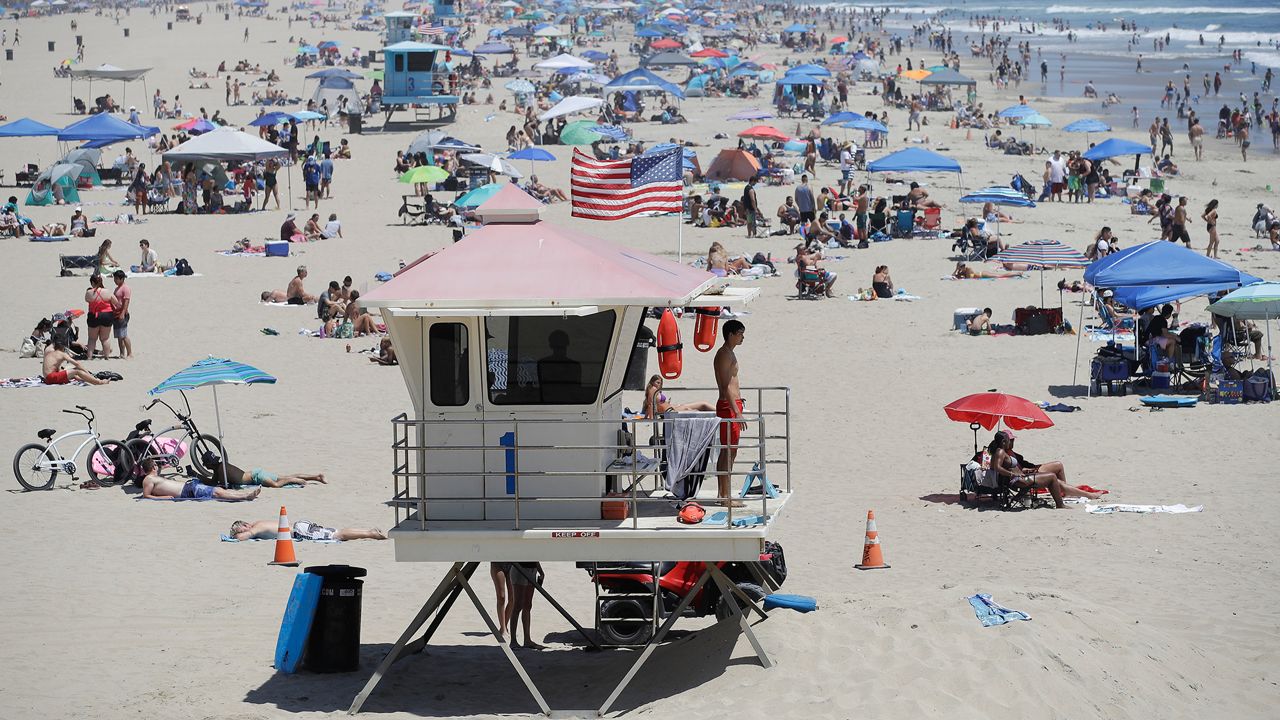 A lifeguard keeps watch over a packed beach in Huntington Beach, Calif on June 27, 2020. (AP Photo/Marcio Jose Sanchez)