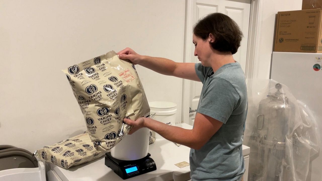 Maggie Songer measures out hops for the day's brew at Salty Turtle Brewing in Surf City. (Spectrum News 1/Alex Wilkinson)