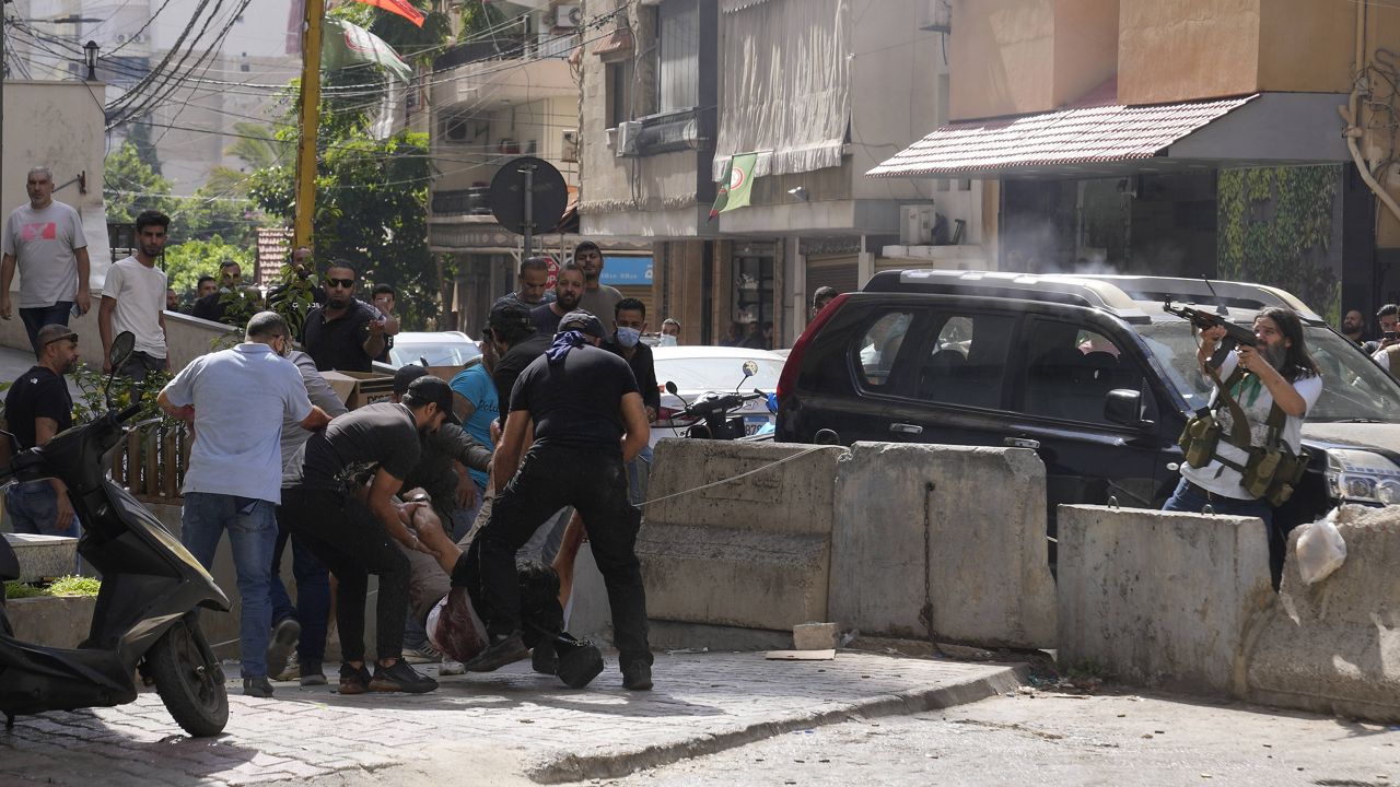 Supporters of a Shiite group allied with Hezbollah help an injured comrade Thursday during armed clashes that erupted during a protest in the southern Beirut suburb of Dahiyeh, Lebanon. (AP Photo/Hassan Ammar)