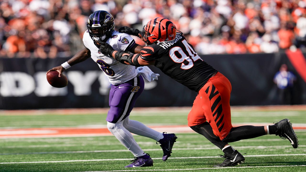 Baltimore Ravens quarterback Lamar Jackson (8) scrambles as Cincinnati Bengals defensive end Sam Hubbard (94) applies pressure during the second half of an NFL football game, Sunday, Oct. 6, 2024, in Cincinnati.