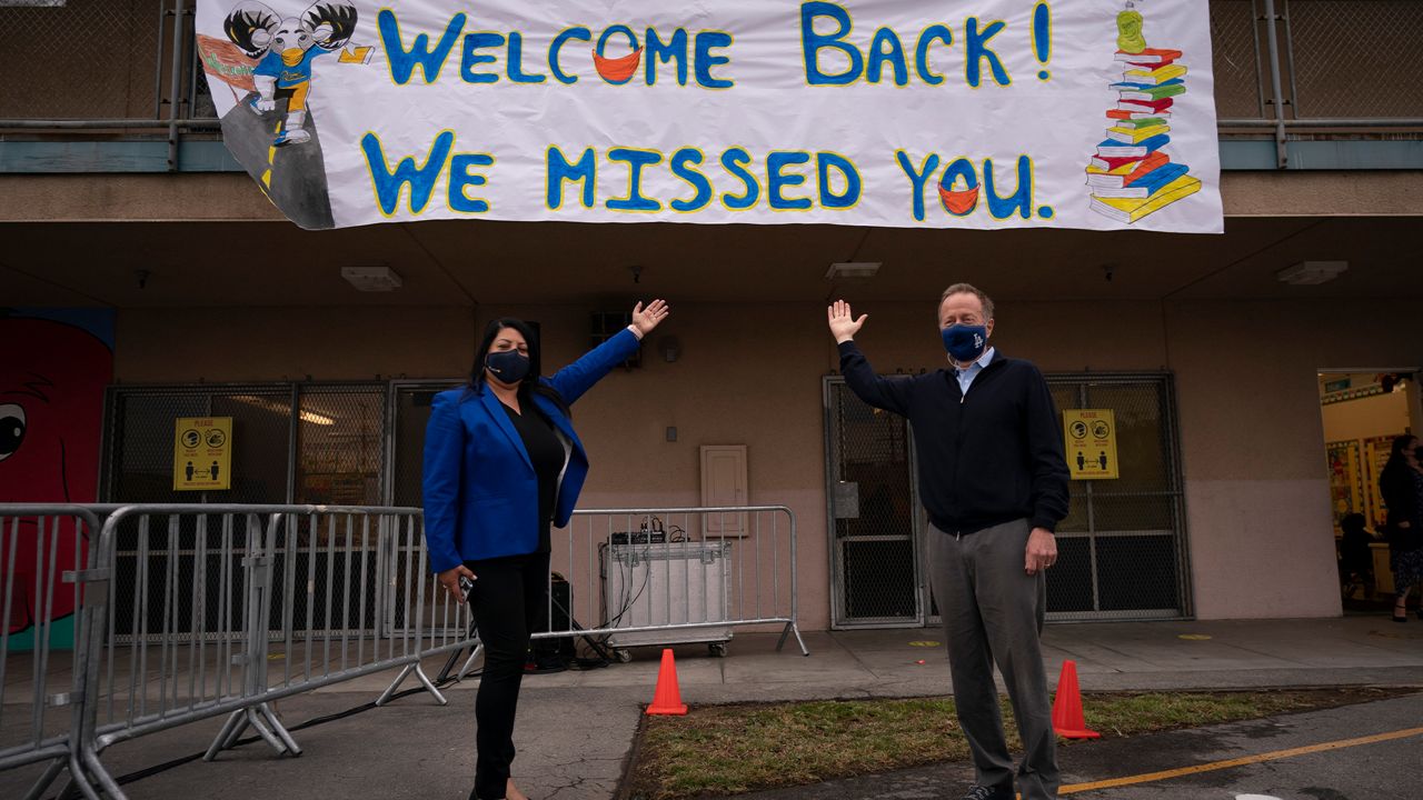 Then LAUSD Superintendent Austin Beutner, right, and Gabriela Rodriguez, principal of Heliotrope Avenue Elementary School, pose for photos on the first day of in-person learning in Maywood, Calif., Tuesday, April 13, 2021. (AP Photo/Jae C. Hong)