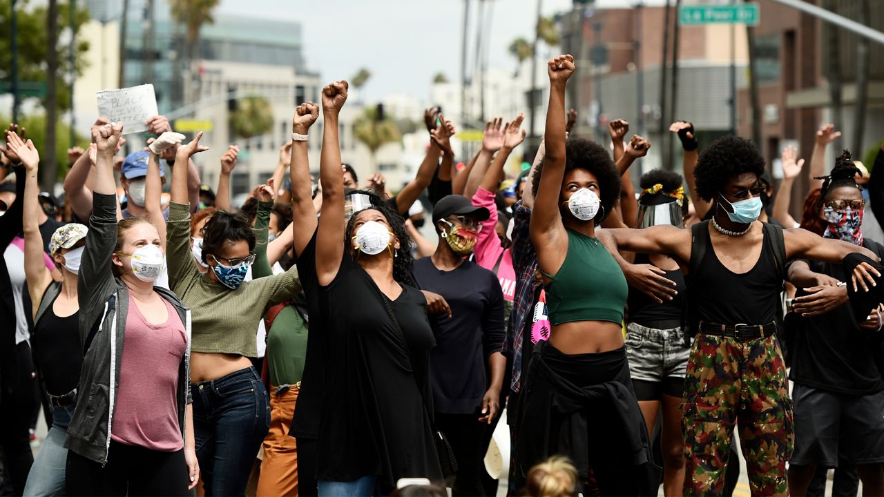 In this June 5, 2020, file photo, protesters raise their fists during a rally in support of Black Lives Matter outside the Academy of Motion Picture Arts & Sciences in Beverly Hills, Calif. Juneteenth 2020 will be a day of protest in may places Friday, June 19. Celebrations held from coast to coast will include marches and demonstrations of civil disobedience. (AP Photo/Chris Pizzello)