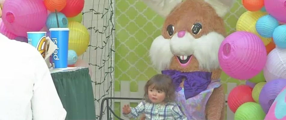 Girl takes picture with Easter Bunny