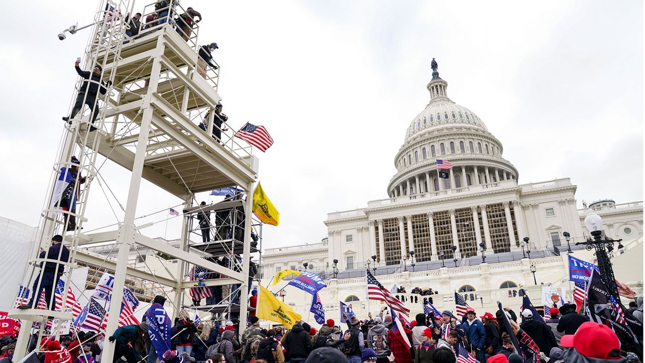 Supporters loyal to President Donald Trump clash with authorities before successfully breaching the Capitol building during a riot on the grounds, Wednesday, Jan. 6, 2021. (AP Photo/John Minchillo)