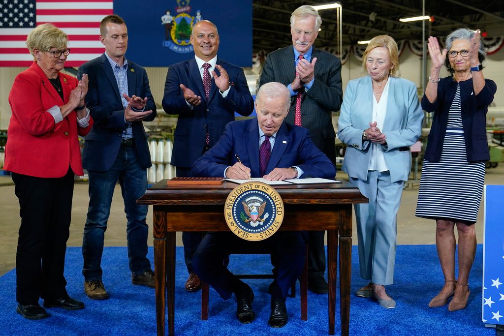 President Joe Biden signs an executive order to encourage companies to manufacture new inventions in the United States at Auburn Manufacturing Inc., in Auburn, Maine, Friday, July 28. From left, Rep. Chellie Pingree, D-Maine, Rep. Jared Golden, D-Maine, Auburn, Maine Mayor Jason Levesque, Sen. Angus King, I-Maine, Maine Gov. Janet Mills, and Kathie Leonard, CEO of Auburn Manufacturing. (AP Photo/Susan Walsh)