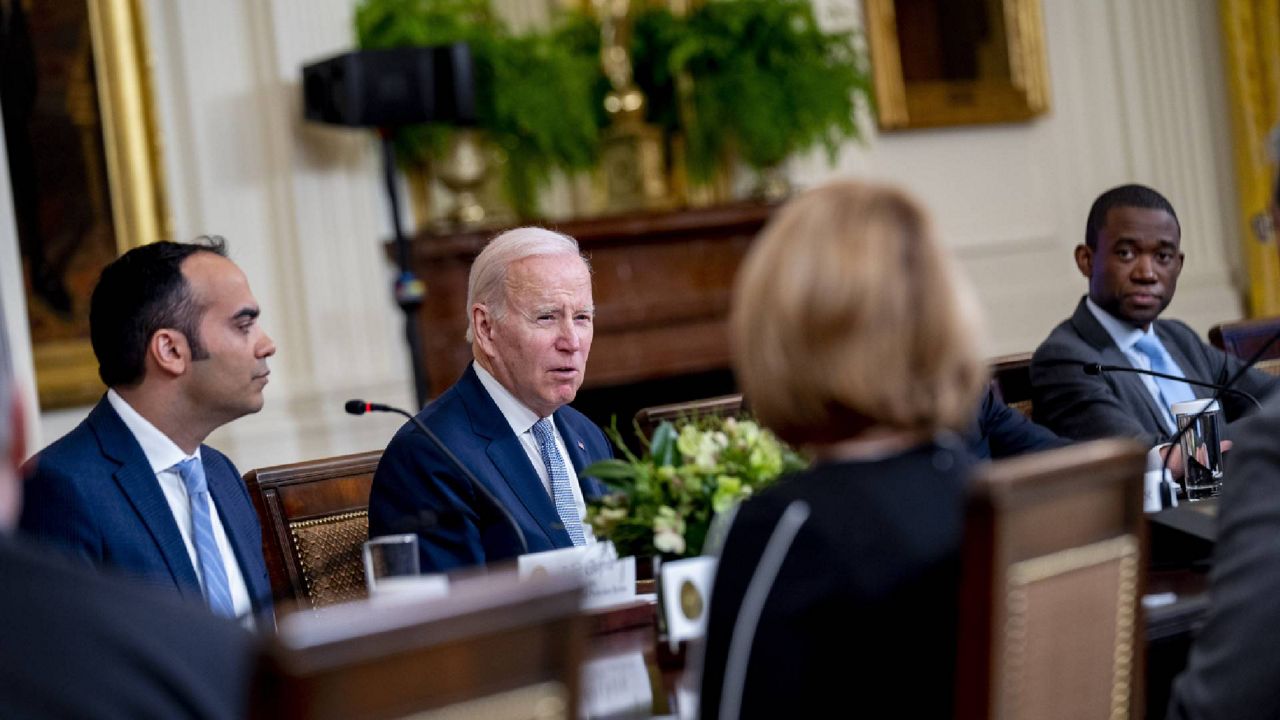 President Joe Biden, center, accompanied by Consumer Financial Protection Bureau director Rohit Chopra, left, and Deputy Treasury Secretary Wally Adeyemo, right, speaks at a meeting with his Competition Council on the economy and consumer prices in the East Room of the White House in Washington, Wednesday, Feb. 1, 2023. (AP Photo/Andrew Harnik)