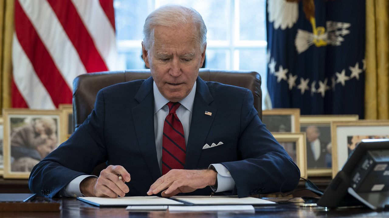 President Joe Biden signs a series of executive orders on health care in the Oval Office of the White House on Thursday. (AP Photo/Evan Vucci)